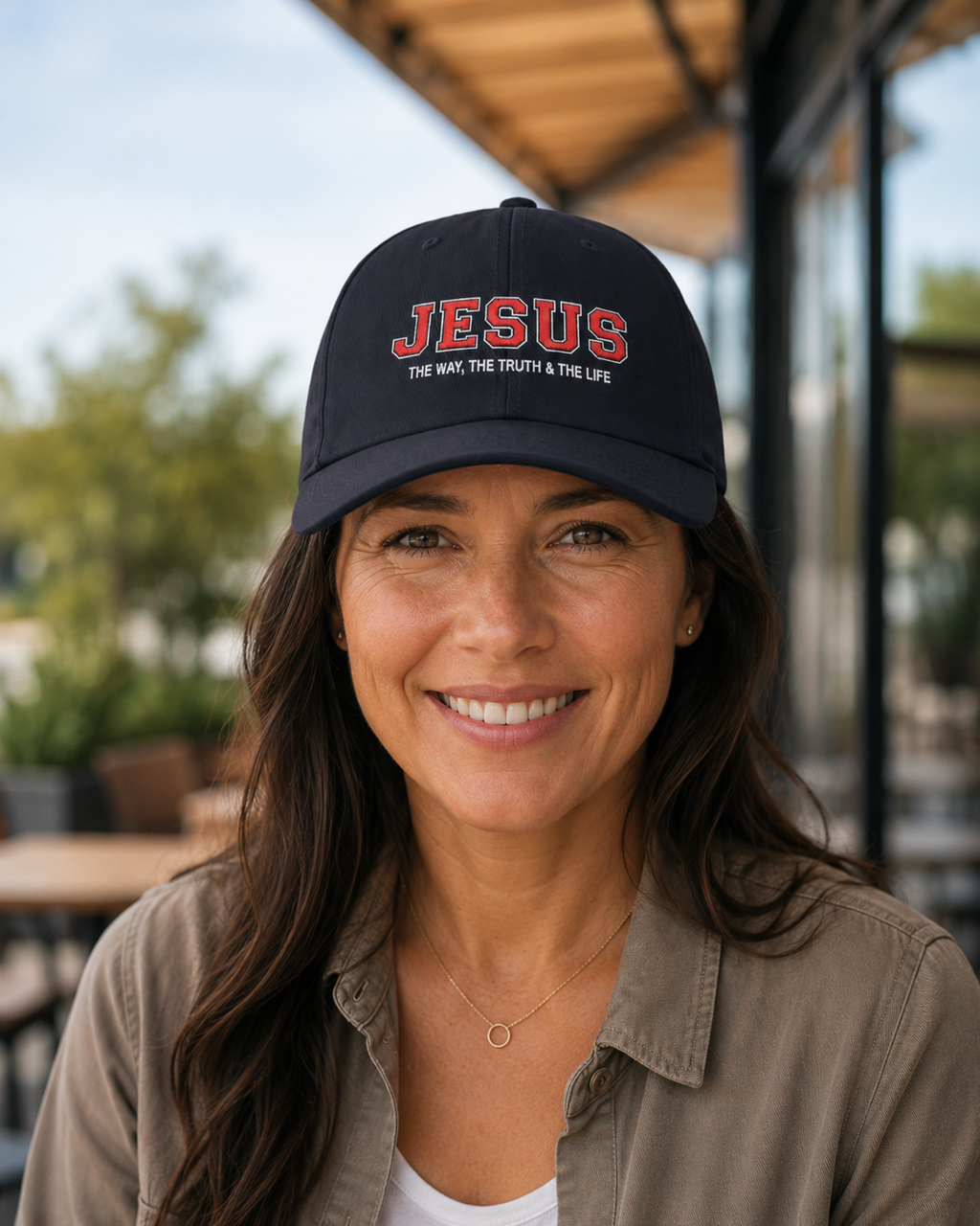 Woman wearing a navy Jesus Christian hat with embroidered “The Way, The Truth & The Life” design at an outdoor café